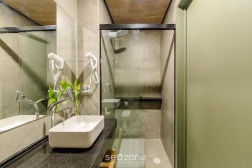 a bathroom with a sink and a shower at NWTs - Estúdios em Prédio com Vista Mar in Maceió