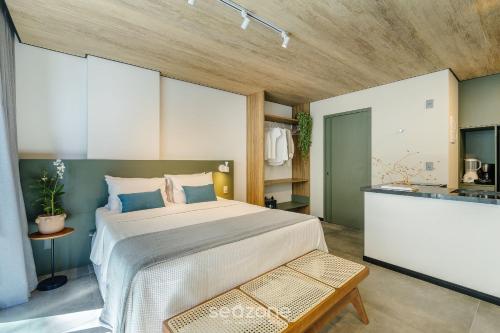 a bedroom with a large bed and a kitchen at NWTs - Estúdios em Prédio com Vista Mar in Maceió