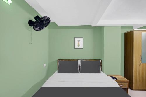 a bedroom with a bed and a clock on the wall at Super Hotel O Olive Residency in Calicut