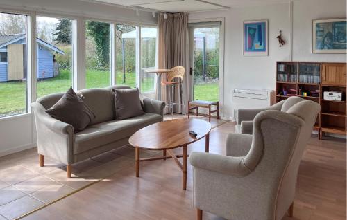 a living room with a couch and chairs and a table at Lovely Home In Kirke Hyllinge in Kirke-Hyllinge