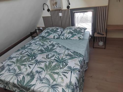 une chambre avec un lit avec un couvre-lit en palmier dans l'établissement Gîte 2 étoiles proche Salers Cantal Auvergne, à Besse