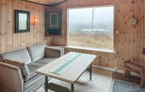 Una sala de estar con un sofá y una mesa y una ventana. en 1 Bedroom Nice Home In Åsnes Finnskog, en Bakken