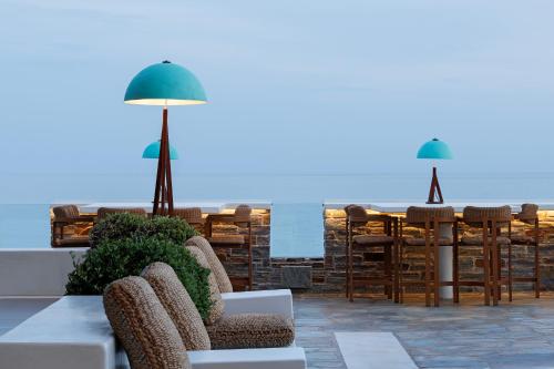 a patio with chairs and a table with a view of the ocean at Anastasia Hotel & Suites Mediterranean Comfort in Karistos