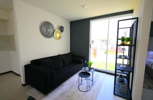 uma sala de estar com um sofá preto e uma mesa em Casa Paris em Assunção