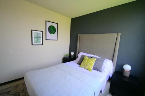 um quarto com uma grande cama branca com travesseiros amarelos em Casa Paris em Assunção