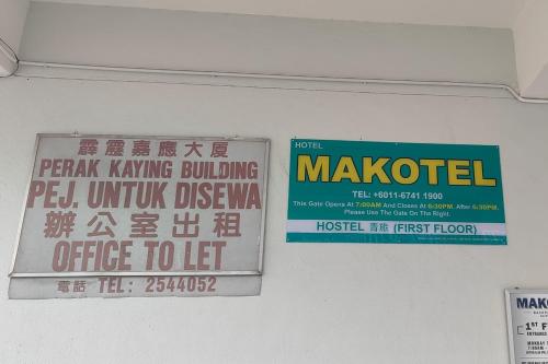 two signs on a wall in a building at Makotel Hostel Ipoh in Ipoh