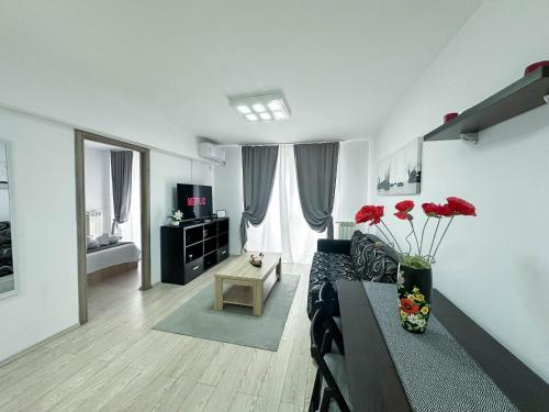 a living room with a couch and red flowers at Sunrise Apartments City Center in Bucharest