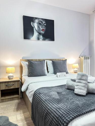 a bedroom with a bed and a black and white picture at Sunrise Apartments City Center in Bucharest