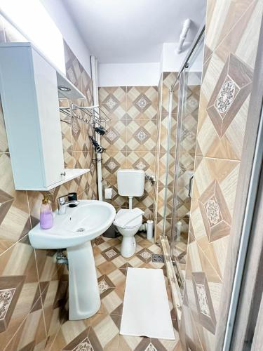a bathroom with a sink and a toilet at Sunrise Apartments City Center in Bucharest