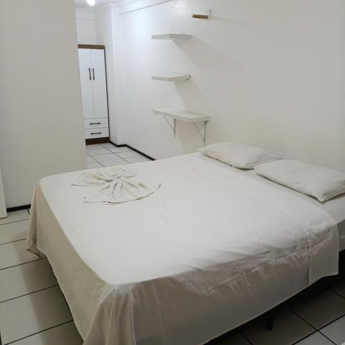 a white bed in a white room with a white wall at Porto de Iracema Vista Mar in Fortaleza