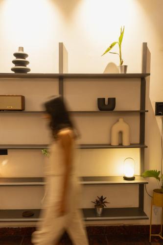 a person walking past a shelf with plants at One-Off Dashashwamedh in Varanasi