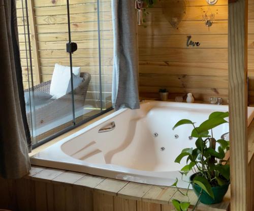 a bath tub in a bathroom with a window at Vila dos Cedros in Rio dos Cedros