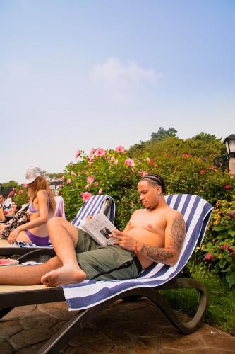 a man sitting on a beach chair reading a newspaper at Cape Colony Inn in Provincetown