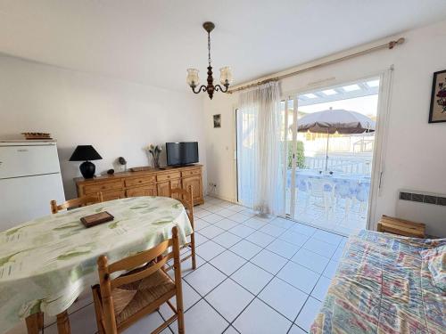 une cuisine et une salle à manger avec une table et un réfrigérateur dans l'établissement Cadre idéal près de l'océan pour 4 personnes à Biscarrosse Plage - FR-1-831-6, à Biscarrosse