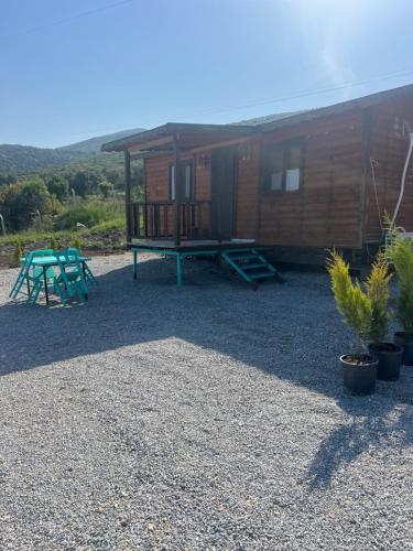 a cabin with a table and a picnic table in front of it at Vrasna Houses in Dikili