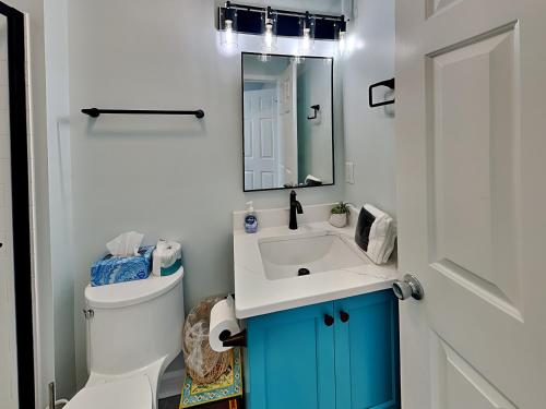 a bathroom with a sink and a toilet and a mirror at Serenity Now in Topsail Beach