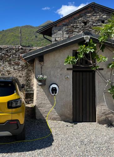 a car with a yellow hose hooked up to a garage at Villa Costantina with heated POOL in Cannobio
