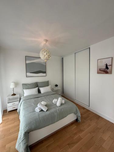 une chambre avec un grand lit avec des serviettes dessus dans l'établissement Luxury and Cozy Apartement In la Defense-Paris, à Courbevoie