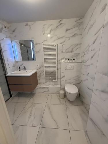 une salle de bain blanche avec un lavabo et des toilettes dans l'établissement Luxury and Cozy Apartement In la Defense-Paris, à Courbevoie