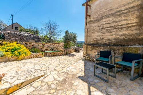 a stone patio with two chairs and a table at House Moj mir in Primošten