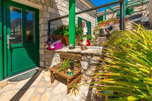 a front porch with a green door and plants at House Moj mir in Primošten