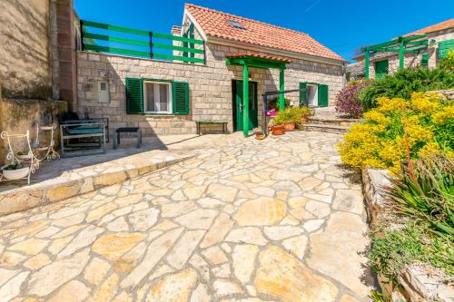 a stone patio in front of a house at House Moj mir in Primošten