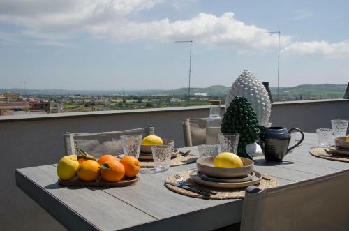 a table with fruit on top of a balcony at Civico Savoia Apartment in Rosolini