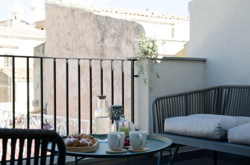 a table with a bowl of fruit on a balcony at Civico Savoia Apartment in Rosolini