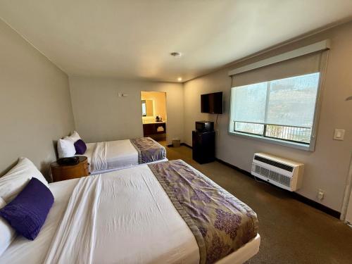 a hotel room with two beds and a window at Heritage Inn San Diego in San Diego