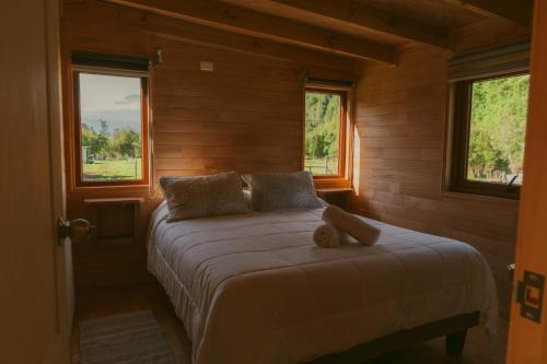 Un dormitorio con una cama con un osito de peluche. en Indómito Refugio, en Puelo
