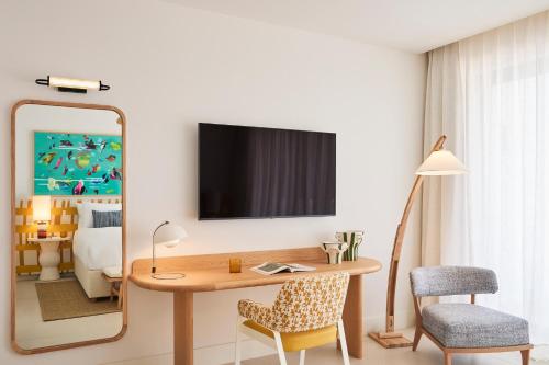 a room with a desk with a mirror and a bedroom at Kimpton Los Monteros Marbella by IHG in Marbella