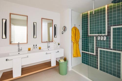a bathroom with two sinks and a shower at Kimpton Los Monteros Marbella by IHG in Marbella