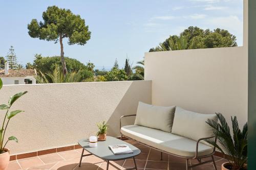 a patio with a white couch and a table at Kimpton Los Monteros Marbella by IHG in Marbella