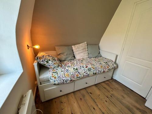 a small bed in a corner of a room at Le Merlin in Saint-Martin-aux-Buneaux