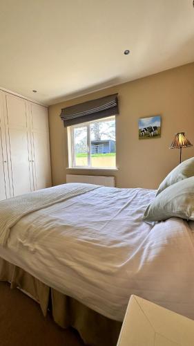 a large white bed in a bedroom with a window at Kelly G's in Feevaghmore