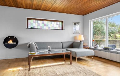 a living room with a couch and a table at Awesome Home In Allinge With Wifi in Allinge