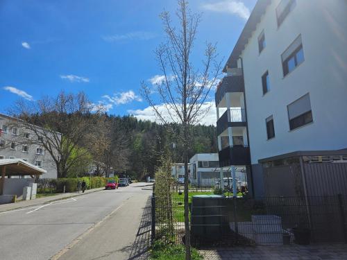 a building on a street with a tree next to it at Traumwohnung Füssen 22 in Füssen