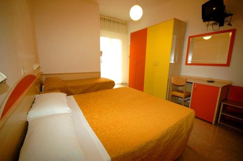 ベッラーリア・イジェア・マリーナにあるHotel Ristoroの大きなベッドとキッチンが備わるホテルルームです。
