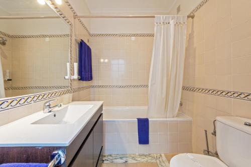 a bathroom with a sink and a tub and a toilet at Hotel Balaia Mar in Albufeira