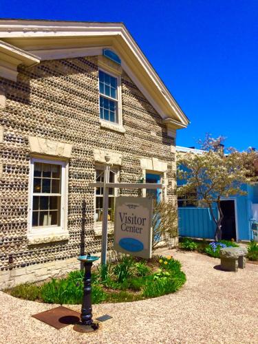 a building with a visitor center sign in front of it at Be Still & Know, Fireplace, Firetable, Walk to Port in Port Washington