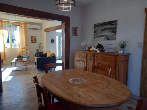 - une salle à manger et un salon avec une table en bois dans l'établissement Gite à la campagne de 2 à 12 pers, à Saint-Jean-de-Marcel