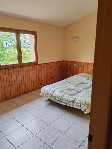 a bedroom with a bed and two windows at Domaine la butte de Lauray in Moncontour-de-Poitou