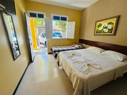 Un dormitorio con dos camas y una ventana. en Pousada Acalanto, en Aracaju