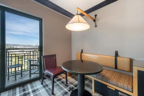 a dining room with a table and a balcony at Omni Interlocken Hotel in Broomfield
