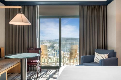 a hotel room with a bed and a table and a balcony at Omni Interlocken Hotel in Broomfield