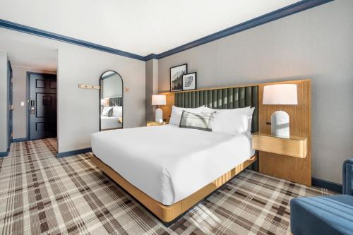 a bedroom with a large white bed and a chair at Omni Interlocken Hotel in Broomfield