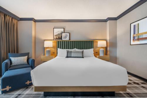 a bedroom with a large bed and a chair at Omni Interlocken Hotel in Broomfield