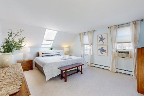 Un dormitorio blanco con una cama y una mesa. en Oak Ridge Retreat, en Sagamore Beach