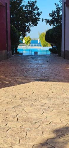 a cobblestone street with trees and a body of water at Apartament Sorrento in Marina Cape in Aheloy