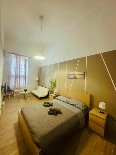 a bedroom with a large bed and a living room at Holiday House Valpiè in Avola